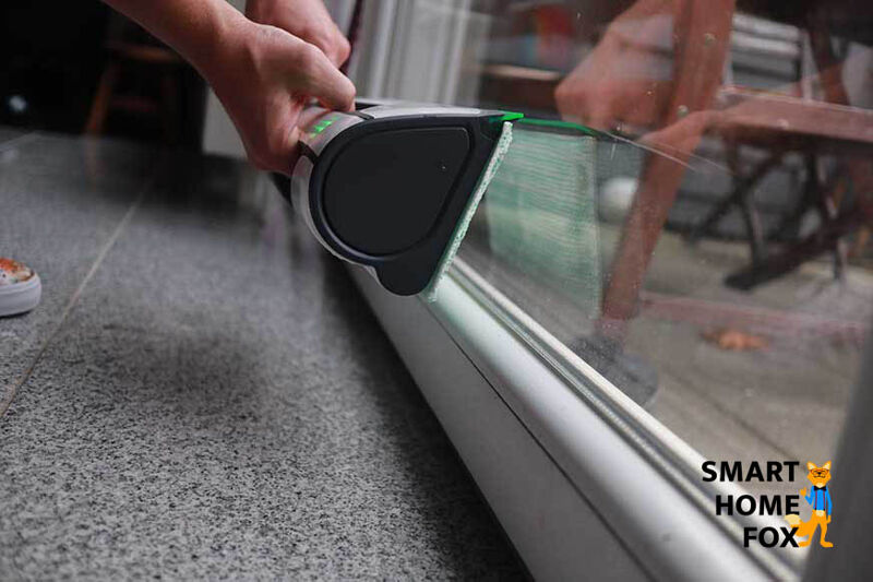 Man sieht, wie der Vorwerk Kobold VG100 am unteren Fensterrand leicht angehoben werden muss.
